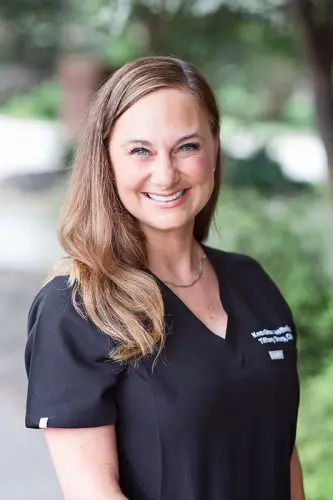 A woman in black shirt smiling for the camera.