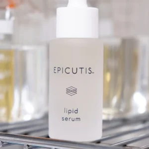 A bottle of liquid serum sitting on top of a rack.