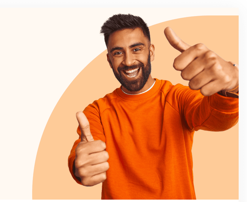 A man in an orange shirt giving two thumbs up.