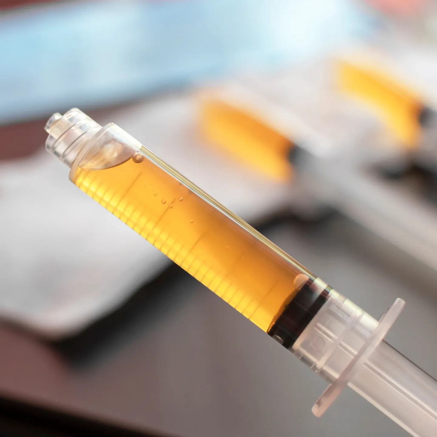 A yellow syringe is sitting on top of a table.